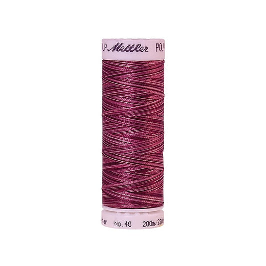 Spool of Mettler dark red variegated thread.