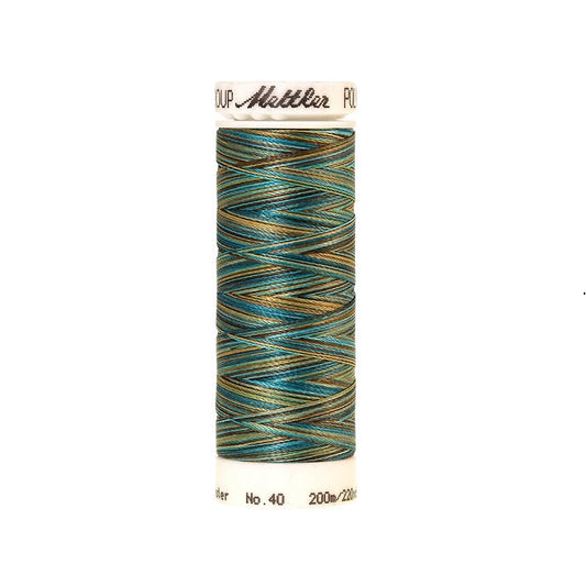 Spool of Mettler green blue and gold variegated thread.