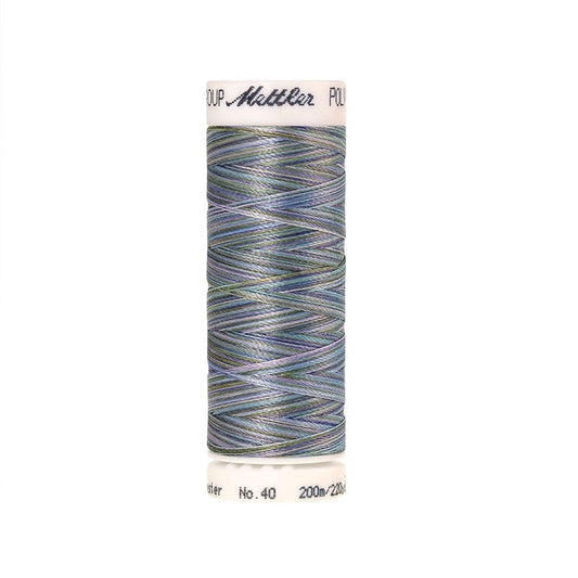 Spool of Mettler blue green and purple variegated thread.