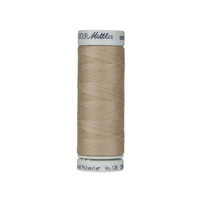 Spool of beige thread with Mettler Seracycle branding.