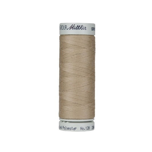 Spool of beige thread with Mettler Seracycle branding.