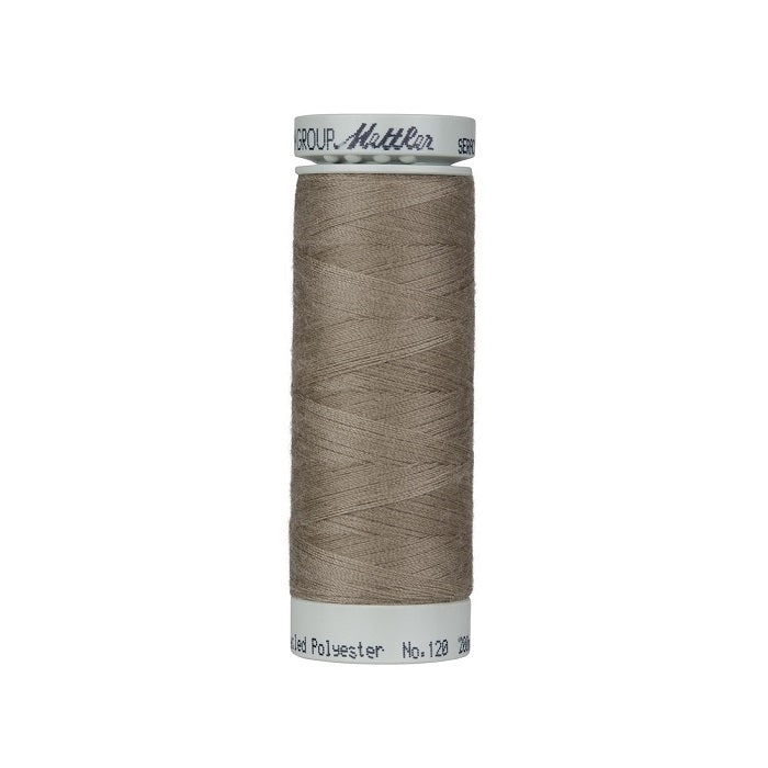 Spool of khaki brown thread with Mettler Seracycle branding.