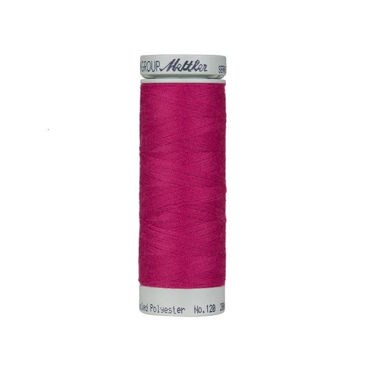 Spool of dark pink thread with Mettler Seracycle branding.