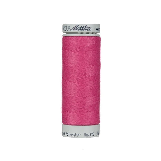 Spool of hot pink thread with Mettler Seracycle branding.