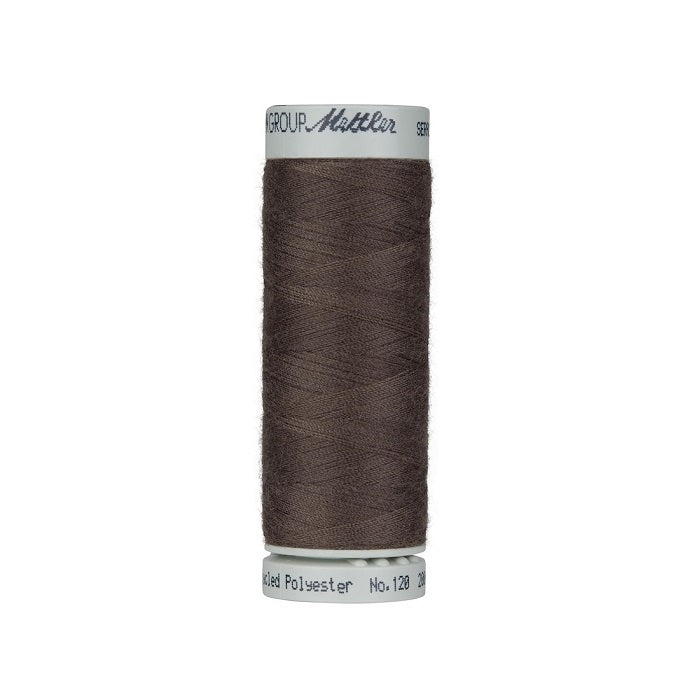 Spool of dark brown thread with Mettler Seracycle branding.