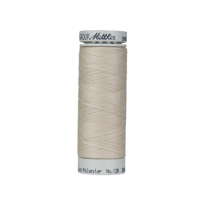 Spool of light beige thread with Mettler Seracycle branding.