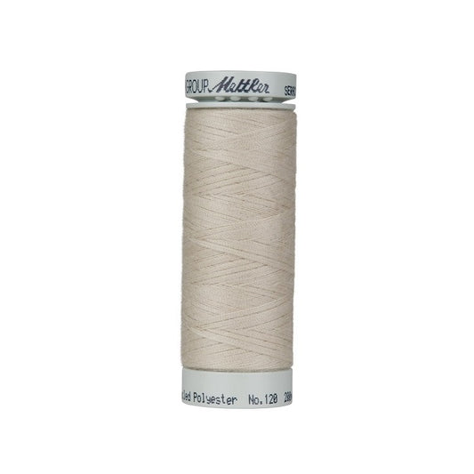 Spool of light beige thread with Mettler Seracycle branding.