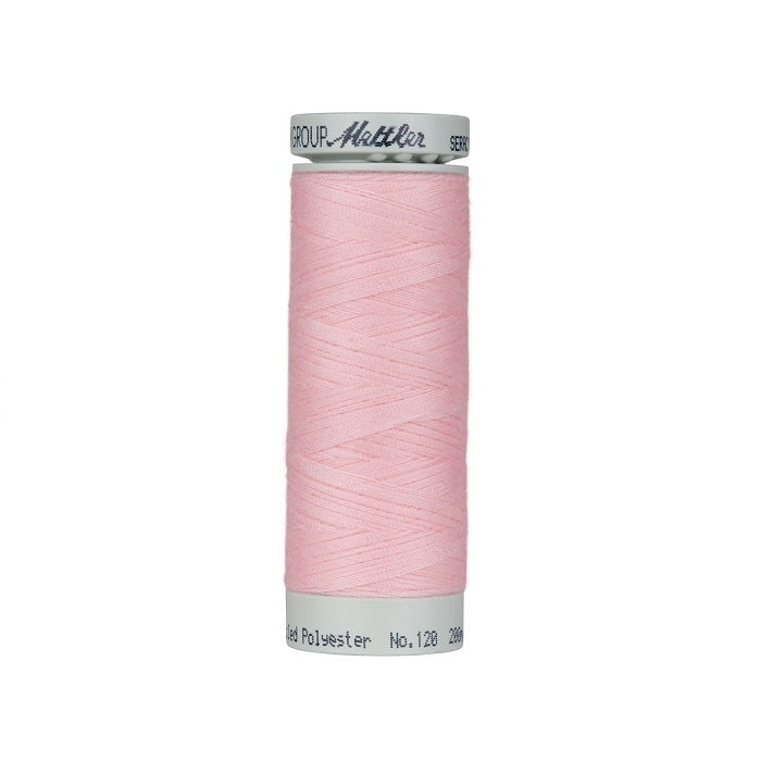 Spool of pink thread with Mettler Seracycle branding.