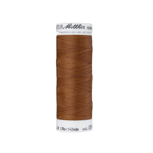 Spool of brown thread with Mettler Seraflex branding.