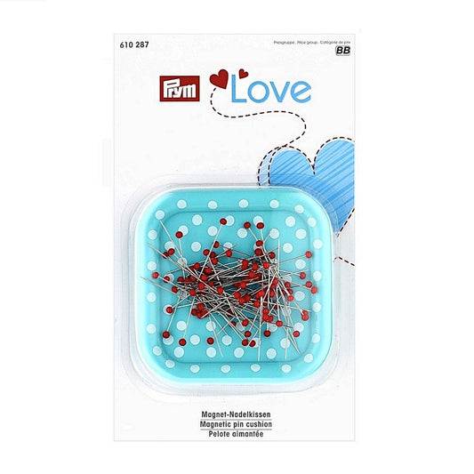 Packaged blue square pin cushion with white dots and red coloured sewing pins.