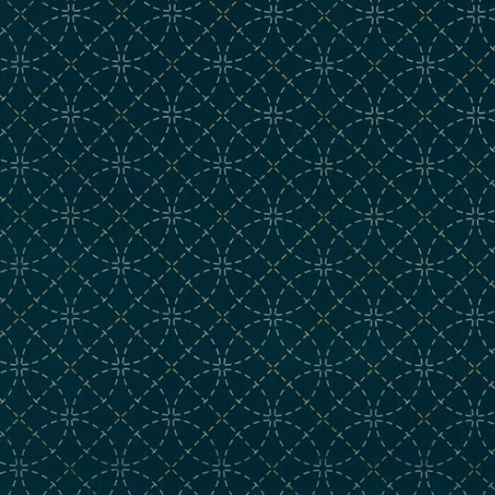 Circular stencil pattern on blue fabric.