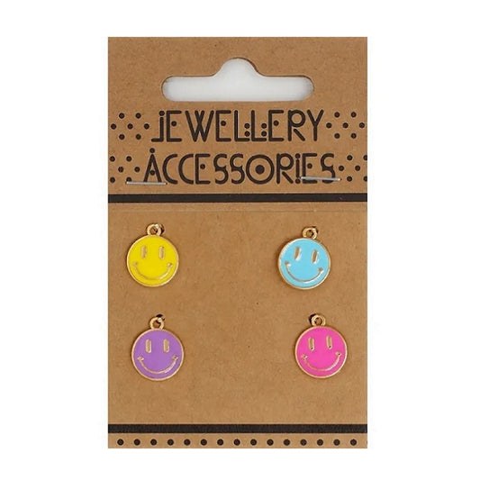 Four smiley face charms on carboard packaging.
