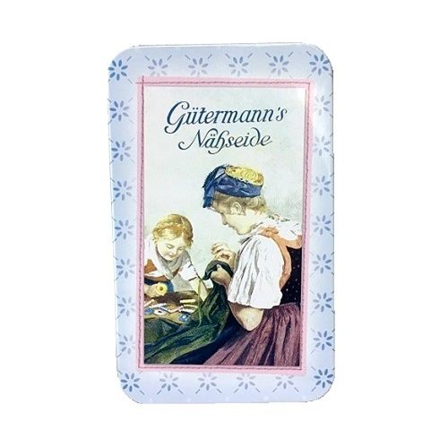 Rectangular vintage style craft storage tin with picture of women sewing on lid.