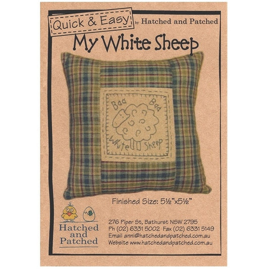 Pattern cover of plaid cushion with embroidered sheep.