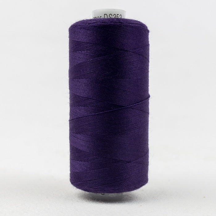 Spool of dark purple thread with Designer branding.