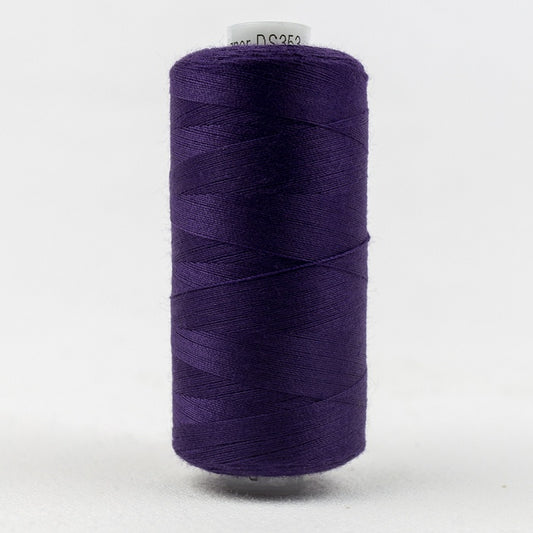 Spool of dark purple thread with Designer branding.
