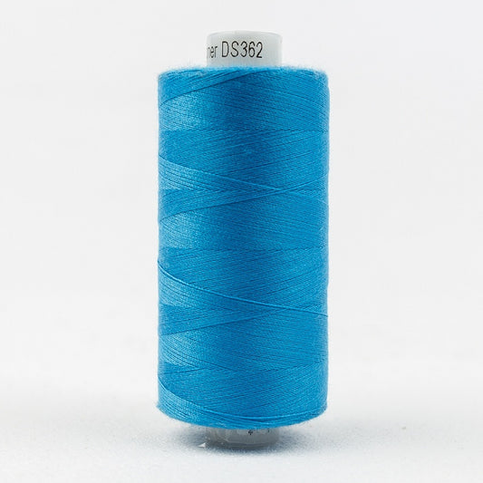 Spool of blue thread with Designer branding.